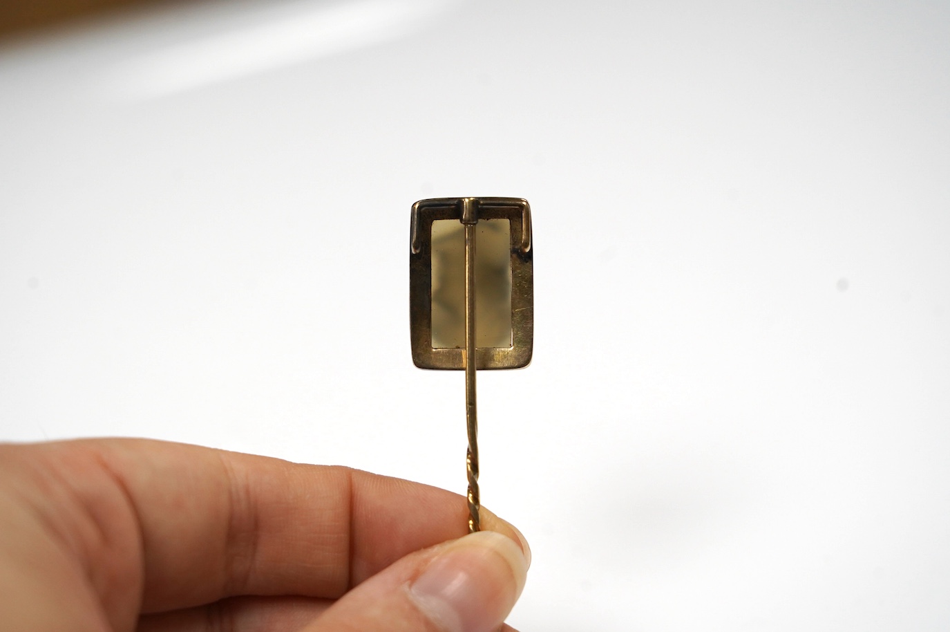 A yellow metal and cameo hardstone set stick pin, 88mm, gross weight 6.9 grams. Condition - poor to fair